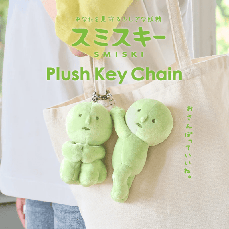 Smiski Hanging On and Hugging Knees plush keyrings hanging from a tote bag