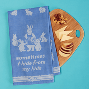 Sometimes I Hide From My Kids tea towel styled beside a chopping board