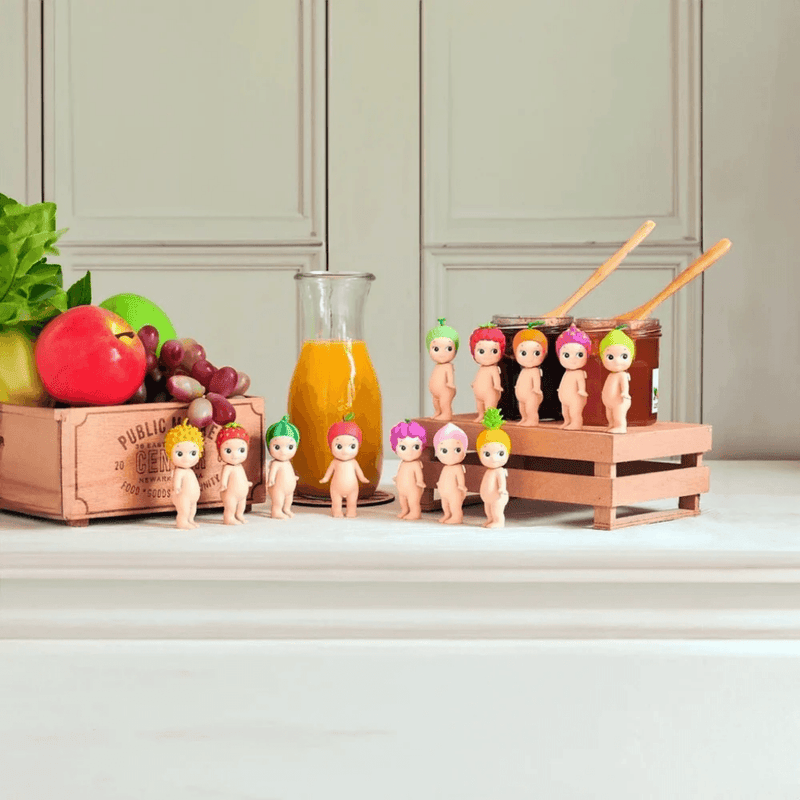 Assorted Sonny Angel Fruit Series collectable figures displayed with fruit