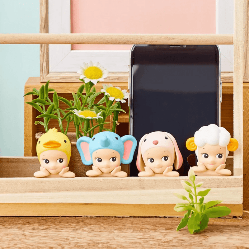 Duck, Sheep and Fawn Sonny Angel Hippers displayed on a phone and wooden rail