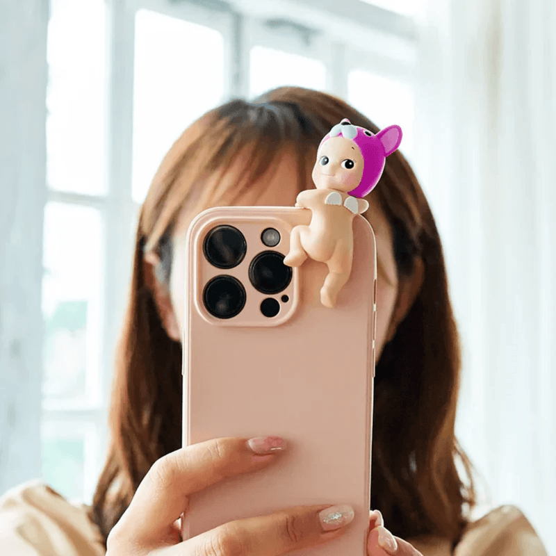 Sonny Angel Hippers Looking Back figure attached to a mobile phone