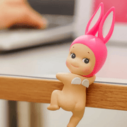 Pink Rabbit Sonny Angel Hippers Looking Back figure attached to an edge
