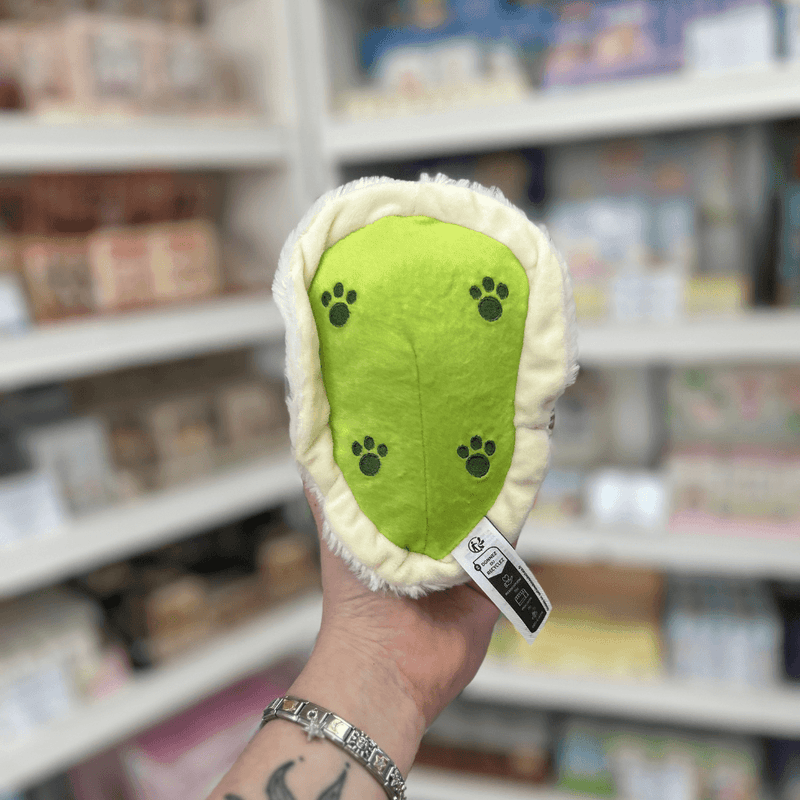 Back view of Squishable Alter Egos Ghost Kitty plush toy showing its green base, paw print details and soft cream fur