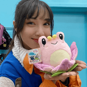 Person holding Squishable Alter Egos Lotus Frog plush toy with pink petals
