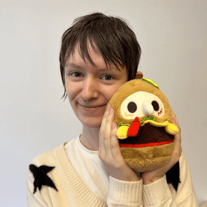 Person holding Squishable Alter Egos Plague Doctor Burger plush toy for size reference