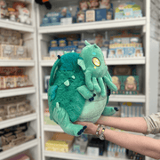 Squishable Baby Cthulhu plush toy held in hands in a gift shop, angled side view