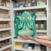 Squishable Baby Cthulhu plush toy held in hands in a gift shop, front view