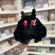 Mini Squishable Baby Mothman black plushie front view with red eyes, tiny feet and soft moth-like wings