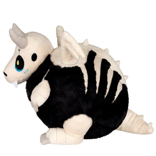 Side profile highlighting embroidered eye, horns and chubby round body of the Bone Dragon plush.