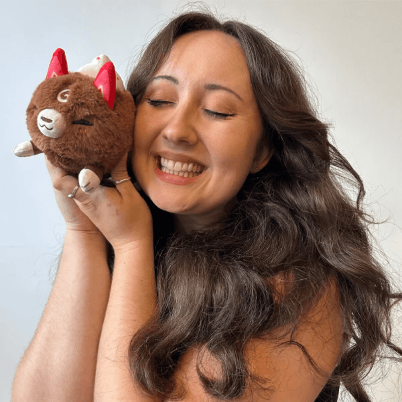 Woman cuddling the Squishable Alter Egos Cocoa Kitsune plush toy