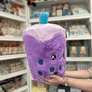 Squishable Comfort Food Bubble Tea plush toy held in hands in a gift shop, angled side view