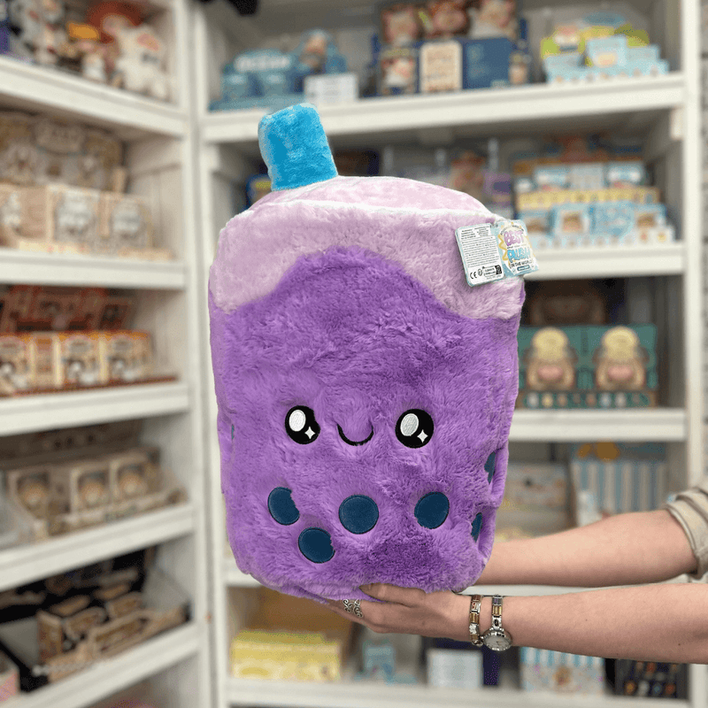 Squishable Comfort Food Bubble Tea plush toy held in hands in a gift shop, front view