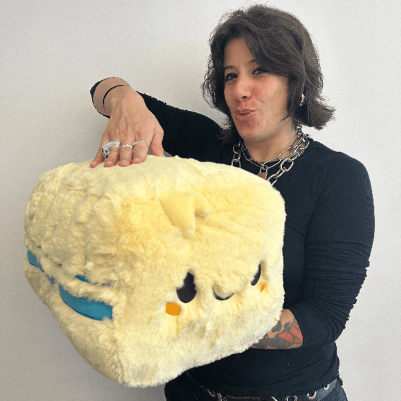 Person holding giant Squishable Comfort Food Butter plush to demonstrate its oversized cuddly shape