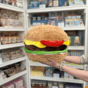 Squishable Comfort Food Cheeseburger plush toy held in hands in a gift shop, back view