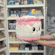 Squishable Comfort Food Happy Birthday Cake plush toy held in hands in a gift shop, side view
