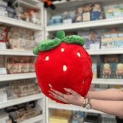 Squishable Comfort Food Strawberry plush toy held in hands in a gift shop, back view