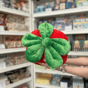 Squishable Comfort Food Strawberry plush toy held in hands in a gift shop, top view showing leafy stem