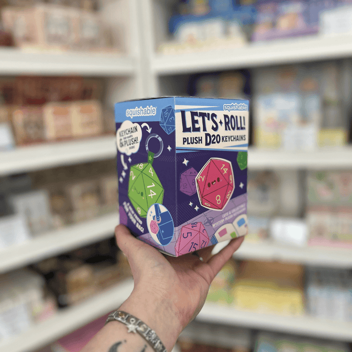 Side view of Squishable Let's Roll D20 Keychain Blind Box showing plush dice keychain artwork and colourful packaging