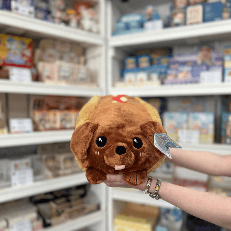 Squishable Dachshund Hot Dog plush toy front view held in hands in a shop