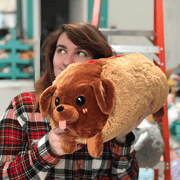 Person holding Squishable Dachshund Hot Dog plush toy in a cuddly lifestyle photo