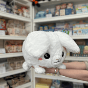 Squishable Fluffy Bunny plush toy angled front view held in hands in a shop