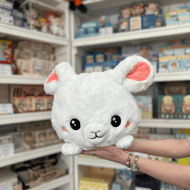 Squishable Fluffy Bunny plush toy held in hands in a shop