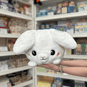 Squishable Fluffy Bunny plush toy front view held in hands in a shop