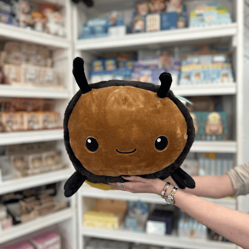 Squishable Fuzzy Bumblebee plush toy held in hands in a gift shop, front view