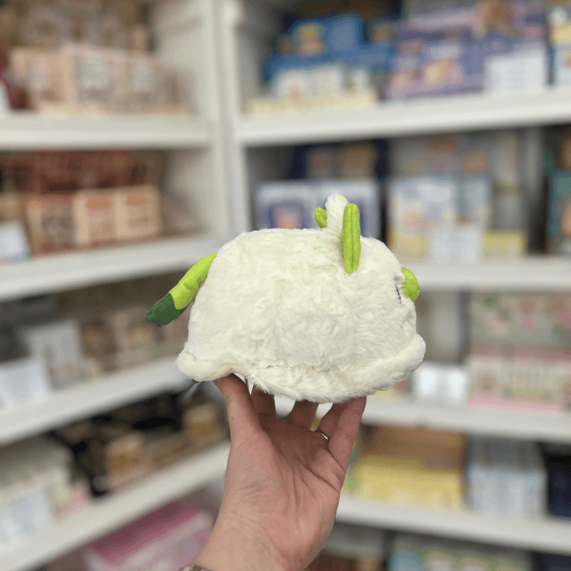 Side view of Squishable Alter Egos Ghost Kitty plushie with soft cream body, green tail and little cat ears