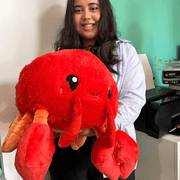 Person holding a large Squishable Lobster plush toy with big red claws