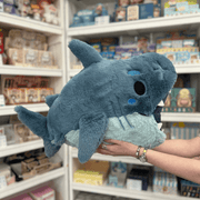 Squishable Megalodon plush toy held in hands in a gift shop, side view with open mouth