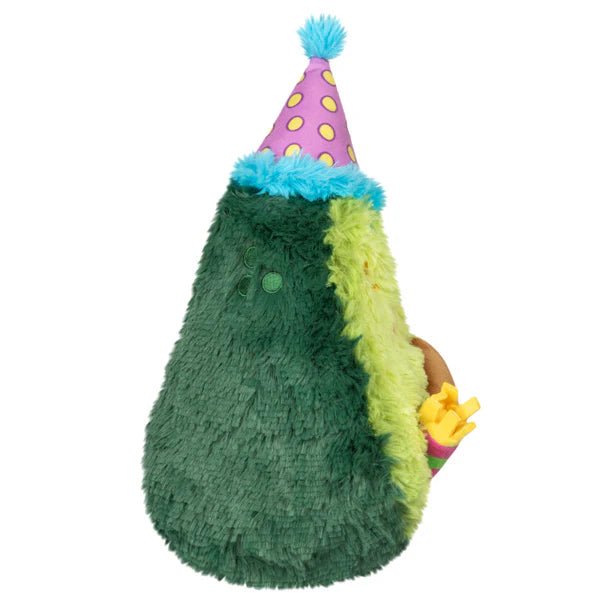 Side view of Mini Comfort Food Birthday Avocado plushie holding a party blower

