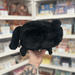 Mini Squishable Black Kitty plush toy held in hand in a gift shop, back view