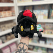 Mini Squishable Black Widow plush toy held in hand in a gift shop, front view