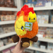 Mini Squishable Campfire plush toy held in hand in a gift shop, side view