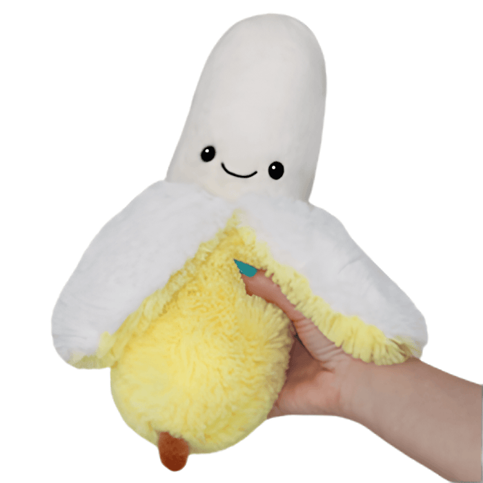 Mini Squishable Comfort Food Banana plush toy held in hand against a plain light background