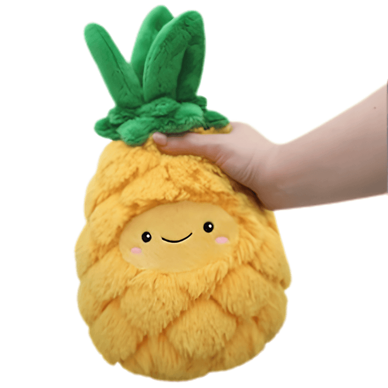 Mini Squishable Comfort Food Pineapple plush toy held in hand against a plain light background
