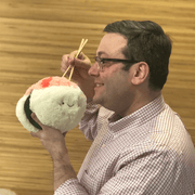 Person holding Squishable Mini Comfort Food Shrimp Sushi plush toy with chopsticks