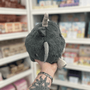 Mini Squishable Gargoyle plush toy held in hand in a gift shop, back view showing tail detail