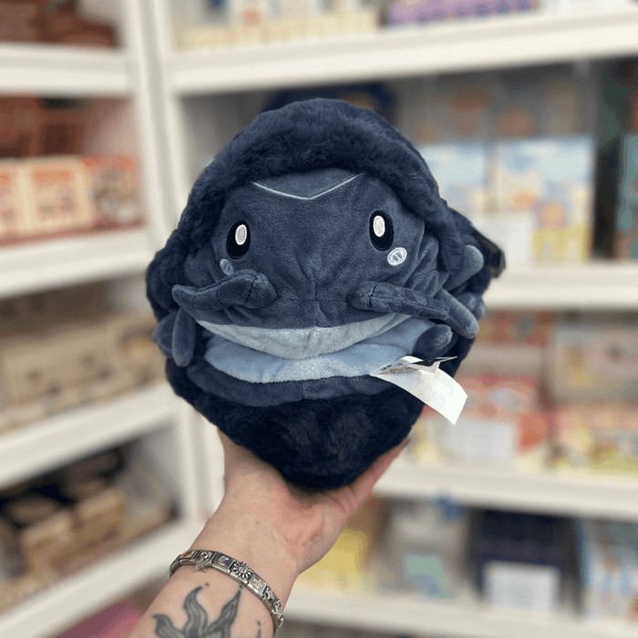 Mini Squishable Pillbug Rollie Pollie plush toy held in hand in a gift shop, front view showing underside detail