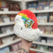 Mini Squishable Rainbow plush toy held in hand in a gift shop, back view