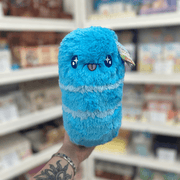 Mini Squishable Sour Gummy Worm plush toy held in hand in a gift shop, front view