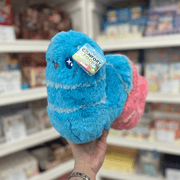 Mini Squishable Sour Gummy Worm plush toy held in hand in a gift shop, side view