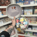 Mini Squishable Trash Can plush toy opened to reveal illustrated rubbish inside, held in hand in a gift shop