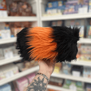 Mini Squishable Woolly Caterpillar plush held in hand in a gift shop, back view