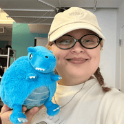 Person holding Squishable Party Snacker Blue T-Rex plush toy in bright blue
