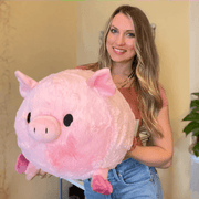 Person holding oversized Squishable Piggy Plush in pale pink
