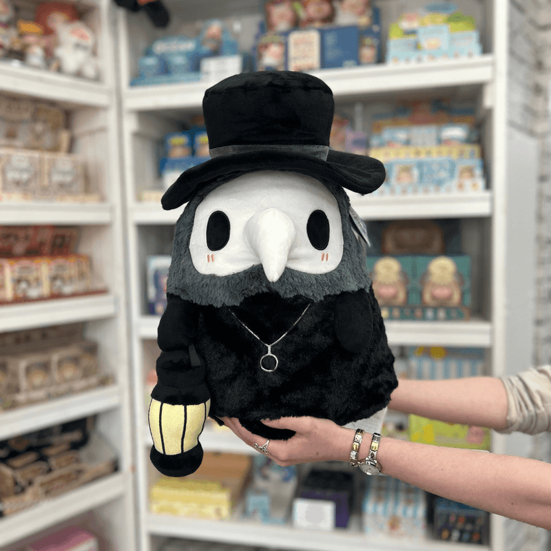 Squishable Plague Doctor plush toy held in hands in a gift shop, front view