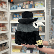 Squishable Plague Doctor plush toy held in hands in a gift shop, side view