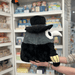 Squishable Plague Doctor plush toy held in hands in a gift shop, side view